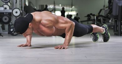 Handsome powerful athletic man performing push ups at the gym. Strong bodybuilder with perfect back, shoulders, biceps, triceps and chest.